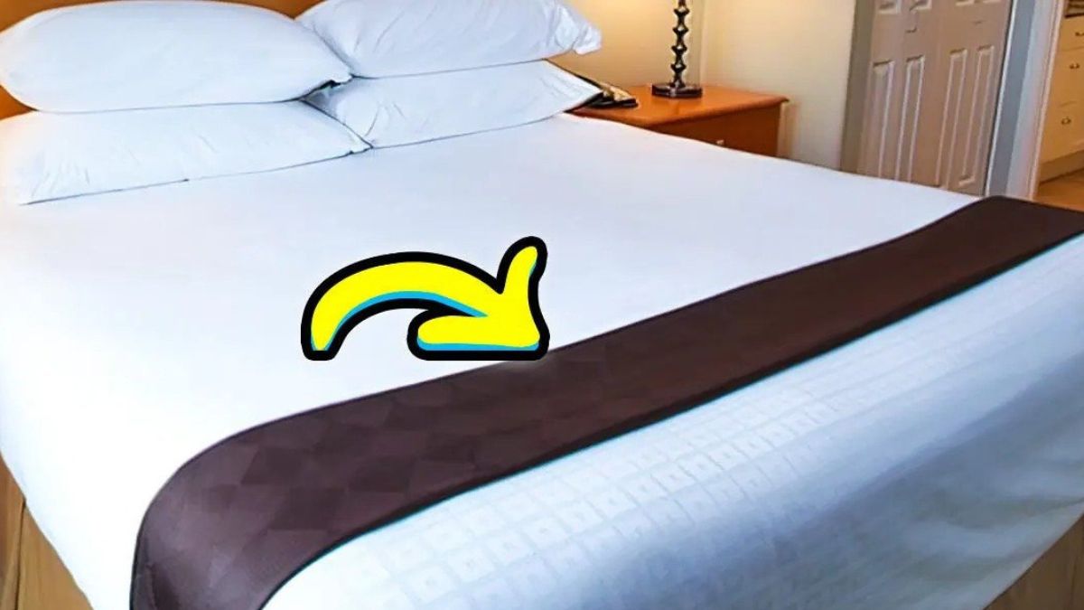 À quoi sert la petite couverture sur le bord du lit d'hôtel ?